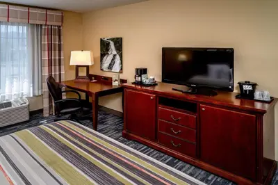 a hotel room with a desk and a flat screen tv at Country Inn & Suites By Radisson, Charleston South, WV in Charleston