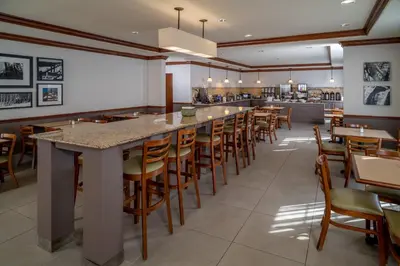 a restaurant with a long bar with wooden stools at Country Inn & Suites By Radisson, Charleston South, WV in Charleston