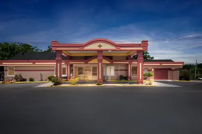 a large red building with a large front at Americas Best Value Inn & Suites Williamstown in Williamstown