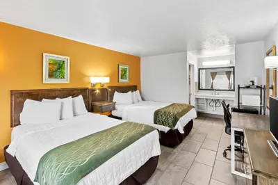 a hotel room with two beds and a television at Americas Best Value Inn & Suites Williamstown in Williamstown