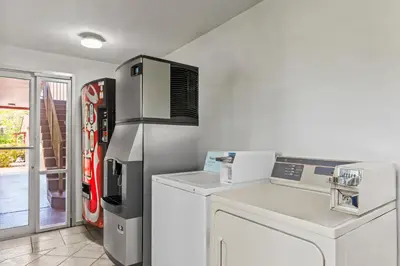 a kitchen with a coke machine and a refrigerator at Americas Best Value Inn & Suites Williamstown in Williamstown