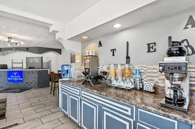 a coffee shop with a counter with a coffee machine at Americas Best Value Inn & Suites Williamstown in Williamstown