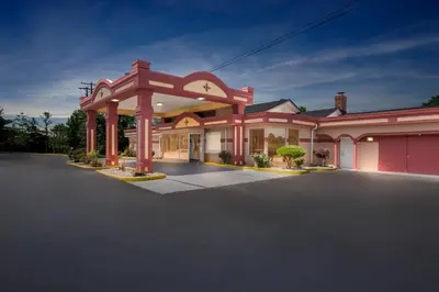 a large pink building with a large driveway at Americas Best Value Inn & Suites Williamstown in Williamstown