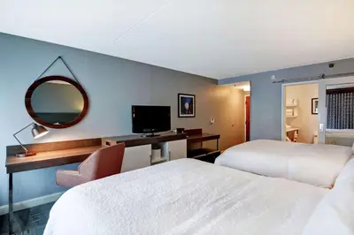 a hotel room with two beds and a desk and a mirror at Hampton Inn Cincinnati Airport South in Florence