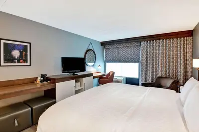 a hotel room with a bed and a desk with a television at Hampton Inn Cincinnati Airport South in Florence