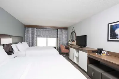 a hotel room with two beds and a television at Hampton Inn Cincinnati Airport South in Florence