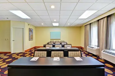 a conference room with tables and chairs and a screen at Hampton Inn Cincinnati Airport South in Florence