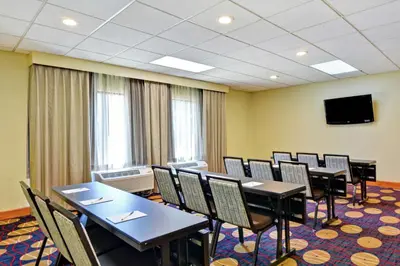 a conference room with tables and chairs and a flat screen tv at Hampton Inn Cincinnati Airport South in Florence