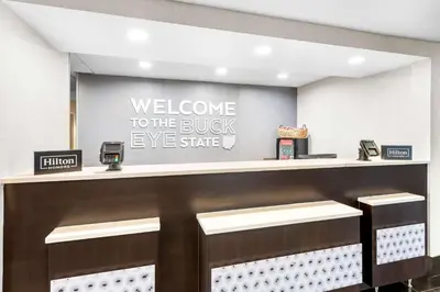 a welcome to the bushy eye store sign above a counter at Hampton Inn Dayton/Huber Heights in Huber Heights