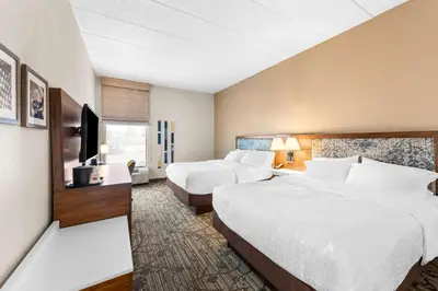 a hotel room with two beds and a flat screen tv at Hampton Inn Dayton/Huber Heights in Huber Heights