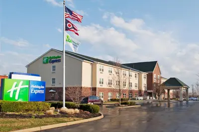 a hotel with flags in a parking lot at Holiday Inn Express & Suites Columbus East - Reynoldsburg by IHG in Reynoldsburg
