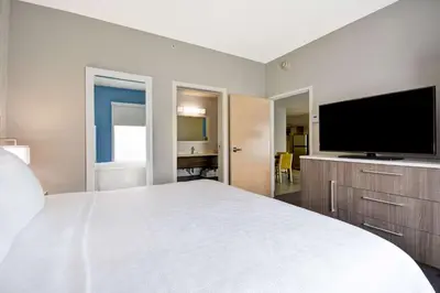 a bedroom with a large bed and a flat screen tv at Home2 Suites By Hilton Blue Ash Cincinnati in Blue Ash