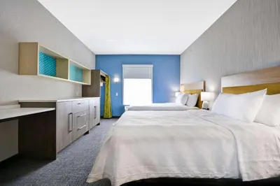 a large bedroom with a large bed and blue walls at Home2 Suites By Hilton Blue Ash Cincinnati in Blue Ash