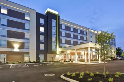 an exterior view of a hotel with a parking lot at Home2 Suites By Hilton Blue Ash Cincinnati in Blue Ash