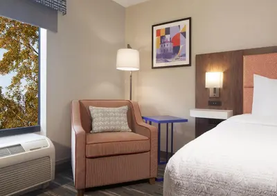 a hotel room with a bed and a chair and a tv at Hampton Inn & Suites Cleveland-Mentor in Mentor