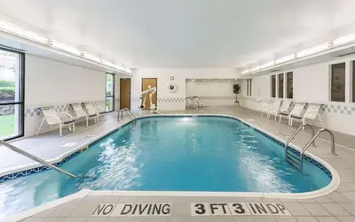 a swimming pool in a hotel room with chairs at Hampton Inn Mansfield/Ontario in Mansfield