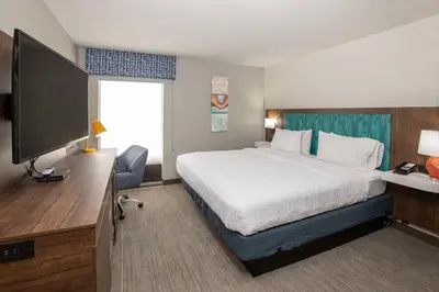 a hotel room with a bed and a flat screen tv at Hampton Inn Dry Ridge in Dry Ridge