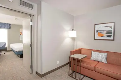 a hotel room with a couch and a bed at Hampton Inn Dry Ridge in Dry Ridge