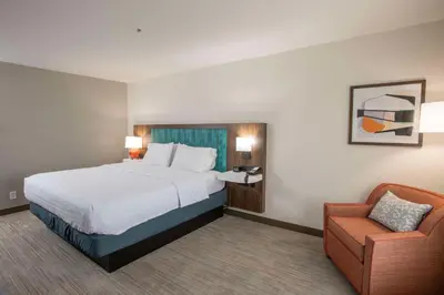a hotel room with a bed and a chair at Hampton Inn Dry Ridge in Dry Ridge
