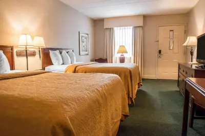 a hotel room with two beds and a television at Quality Inn Pittsburgh Airport in Oakdale