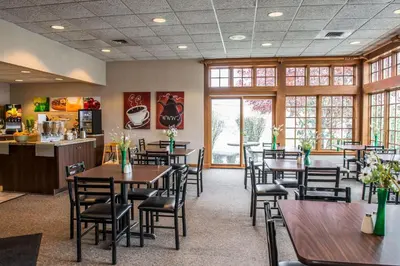 a restaurant with tables and chairs in a room at Quality Inn Pittsburgh Airport in Oakdale