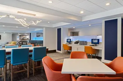 a waiting room with tables and chairs at Holiday Inn Express & Suites Cincinnati Riverfront by IHG in Covington