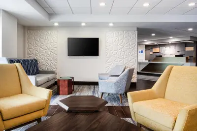 a waiting room with two chairs and a flat screen tv at Holiday Inn Express & Suites Cincinnati Riverfront by IHG in Covington