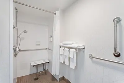 a bathroom with a shower and white towels at Holiday Inn Express & Suites Cincinnati Riverfront by IHG in Covington