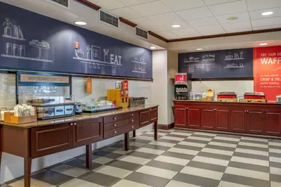 a fast food restaurant with a counter and signs on the wall at Hampton Inn Greenfield in Greenfield