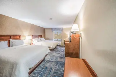 a hotel room with two beds and a room with two at Hampton Inn Greenfield in Greenfield