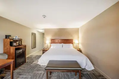 a hotel room with a bed and a table at Hampton Inn Greenfield in Greenfield