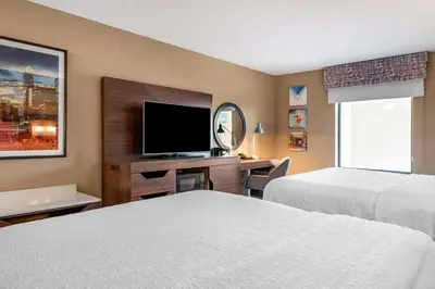 a hotel room with two beds and a flat screen tv at Hampton Inn Greenfield in Greenfield