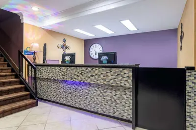 a lobby with a counter and a clock on the wall at Days Inn by Wyndham Anderson IN in Anderson