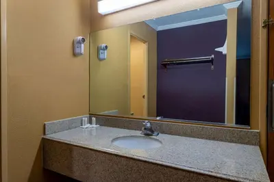 a bathroom with a sink and a large mirror at Days Inn by Wyndham Anderson IN in Anderson