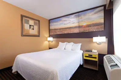 a hotel room with a large bed and a chair at Days Inn by Wyndham Anderson IN in Anderson