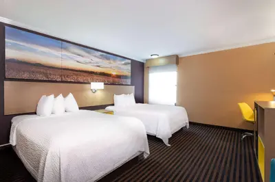 a hotel room with two beds and a painting on the wall at Days Inn by Wyndham Anderson IN in Anderson
