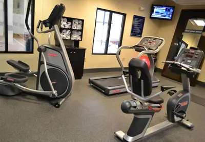 a gym with three exercise bikes and a treadmill at Hampton Inn & Suites Dayton-Airport in Englewood