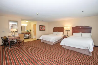 a hotel room with two beds and a desk at Hampton Inn & Suites Dayton-Airport in Englewood