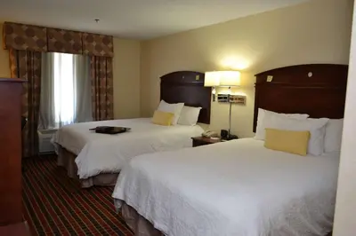 a hotel room with two beds with white sheets at Hampton Inn & Suites Dayton-Airport in Englewood