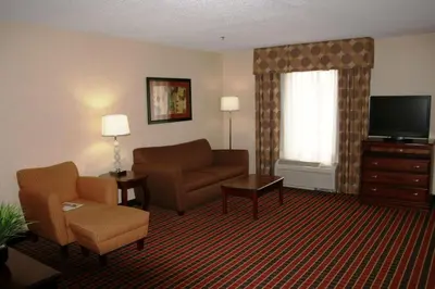 a living room with a couch chair and a television at Hampton Inn & Suites Dayton-Airport in Englewood