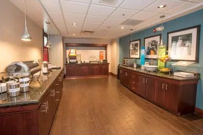 a waiting room with a counter in a restaurant at Hampton Inn & Suites Dayton-Airport in Englewood