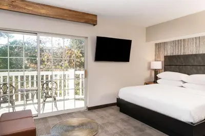 a hotel room with a bed and a balcony at Cherry Valley Hotel in Newark