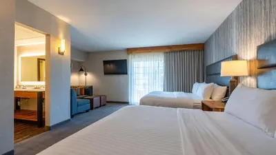 a hotel room with two beds and a desk at Cherry Valley Hotel in Newark