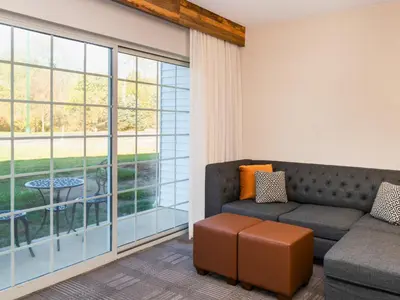 a living room with a couch and a large window at Cherry Valley Hotel in Newark