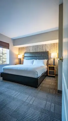 a bedroom with a large bed and two lamps at Cherry Valley Hotel in Newark