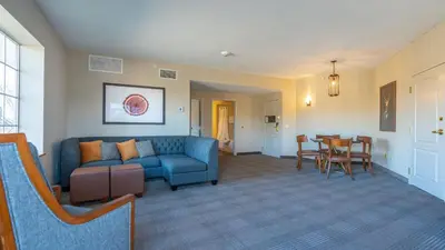 a living room with a blue couch and a table at Cherry Valley Hotel in Newark
