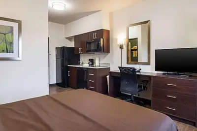 a hotel room with a bed and a desk with a computer at Suburban Studios Monaca - Pittsburgh in Monaca