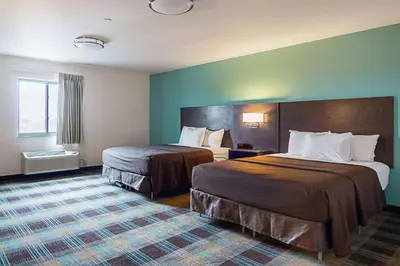 a hotel room with two beds and a window at Suburban Studios Monaca - Pittsburgh in Monaca