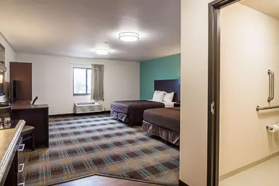 a hotel room with two beds and a kitchen at Suburban Studios Monaca - Pittsburgh in Monaca