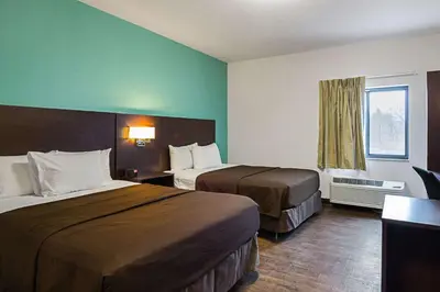 a hotel room with two beds and a window at Suburban Studios Monaca - Pittsburgh in Monaca